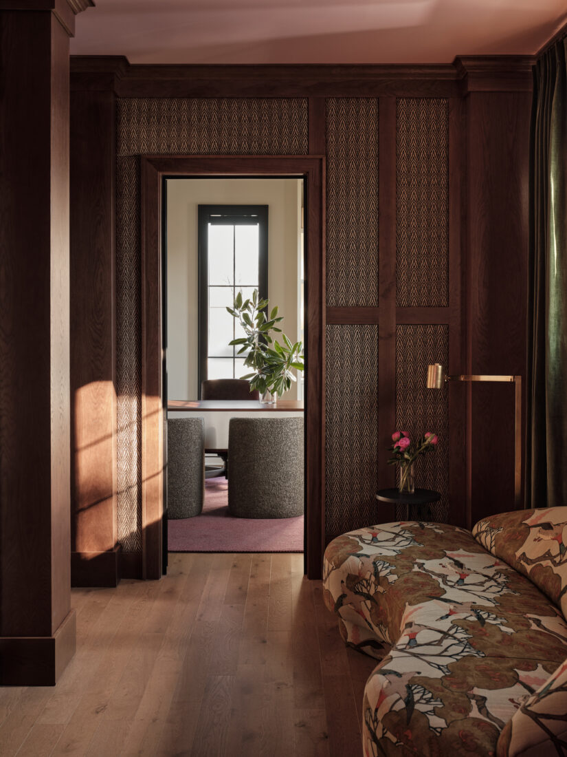 A hallway with a kidney-shaped sofa with printed fabric