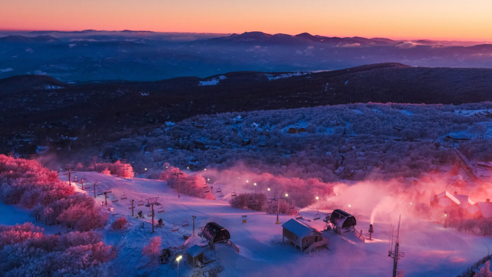 A sun sets over a ski resorts