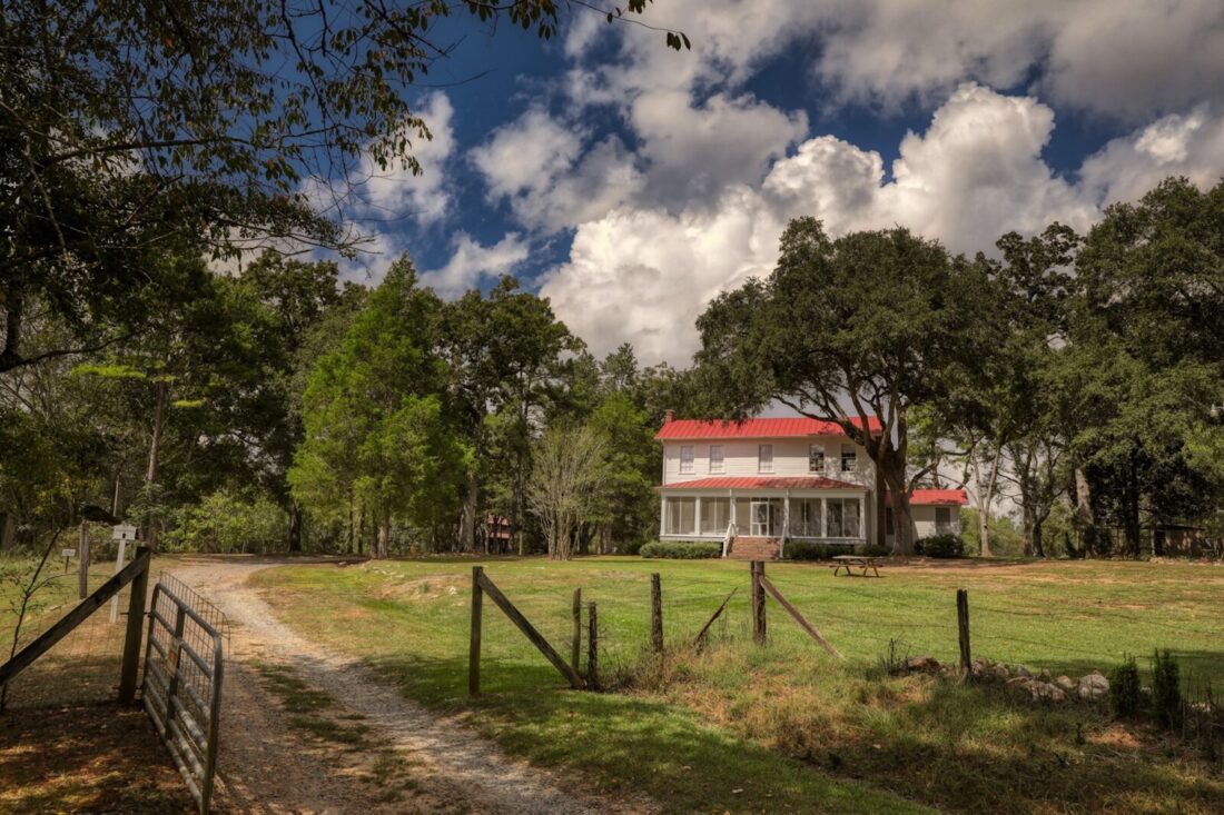 A farmhouse behind a fence