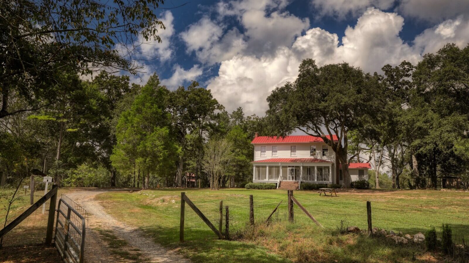 A farmhouse behind a fence