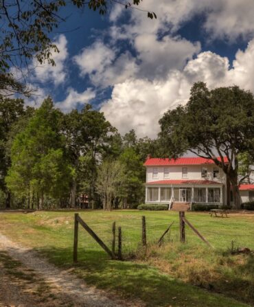 A farmhouse behind a fence