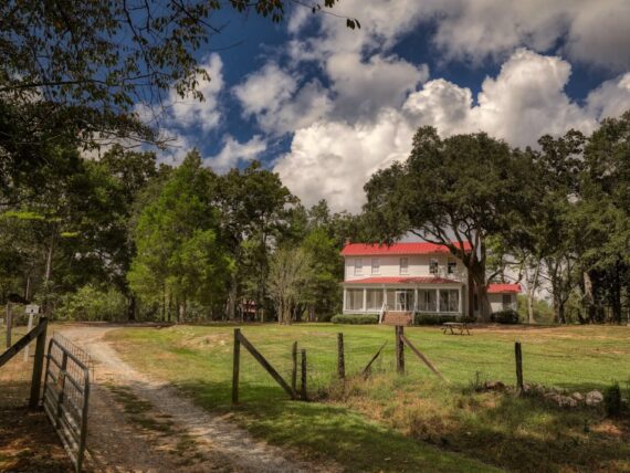 A farmhouse behind a fence