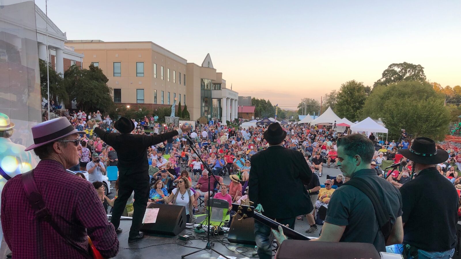 A crowd of people gather in front of a stage