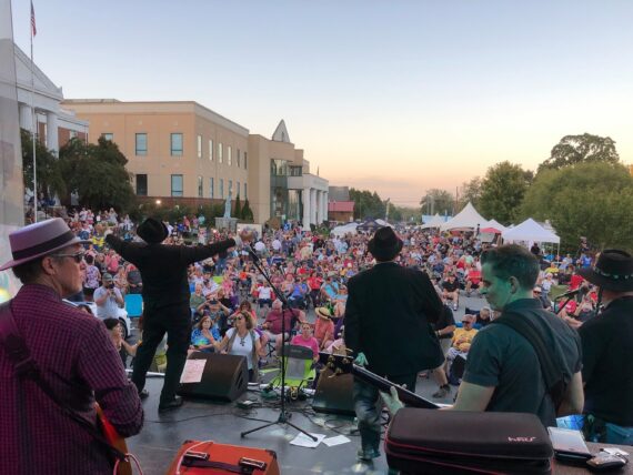 A crowd of people gather in front of a stage