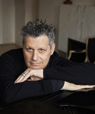 A portrait of a man with curly grey hair