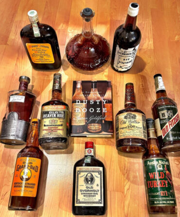 a wood background with 10 bottles of bourbon surrounding a book.