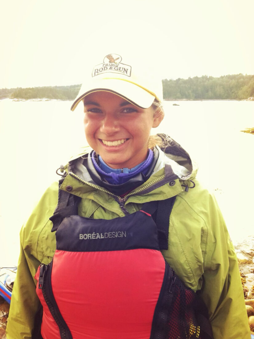 A woman in fishing gear near water