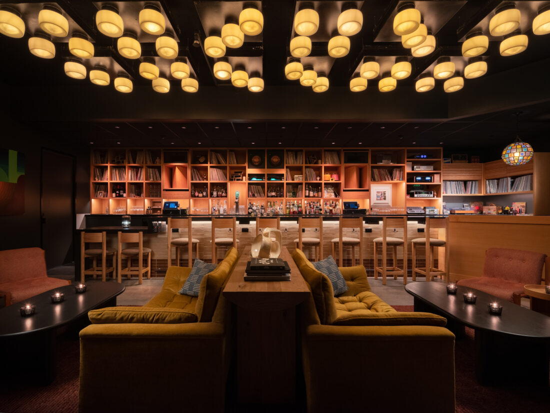 A bar lounge with many circular lights on the ceiling and vinyl listening equipment