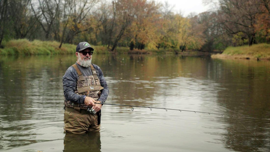 A man stands in a river and fly fishes
