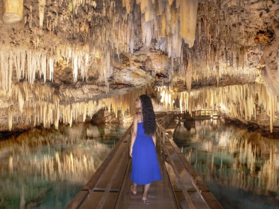 A woman walks down a cave system