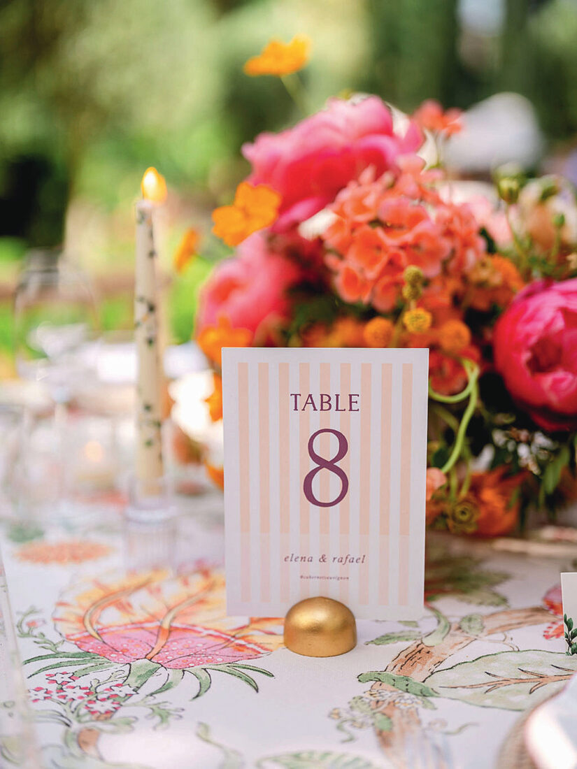 A placed table card beside a vase of florals
