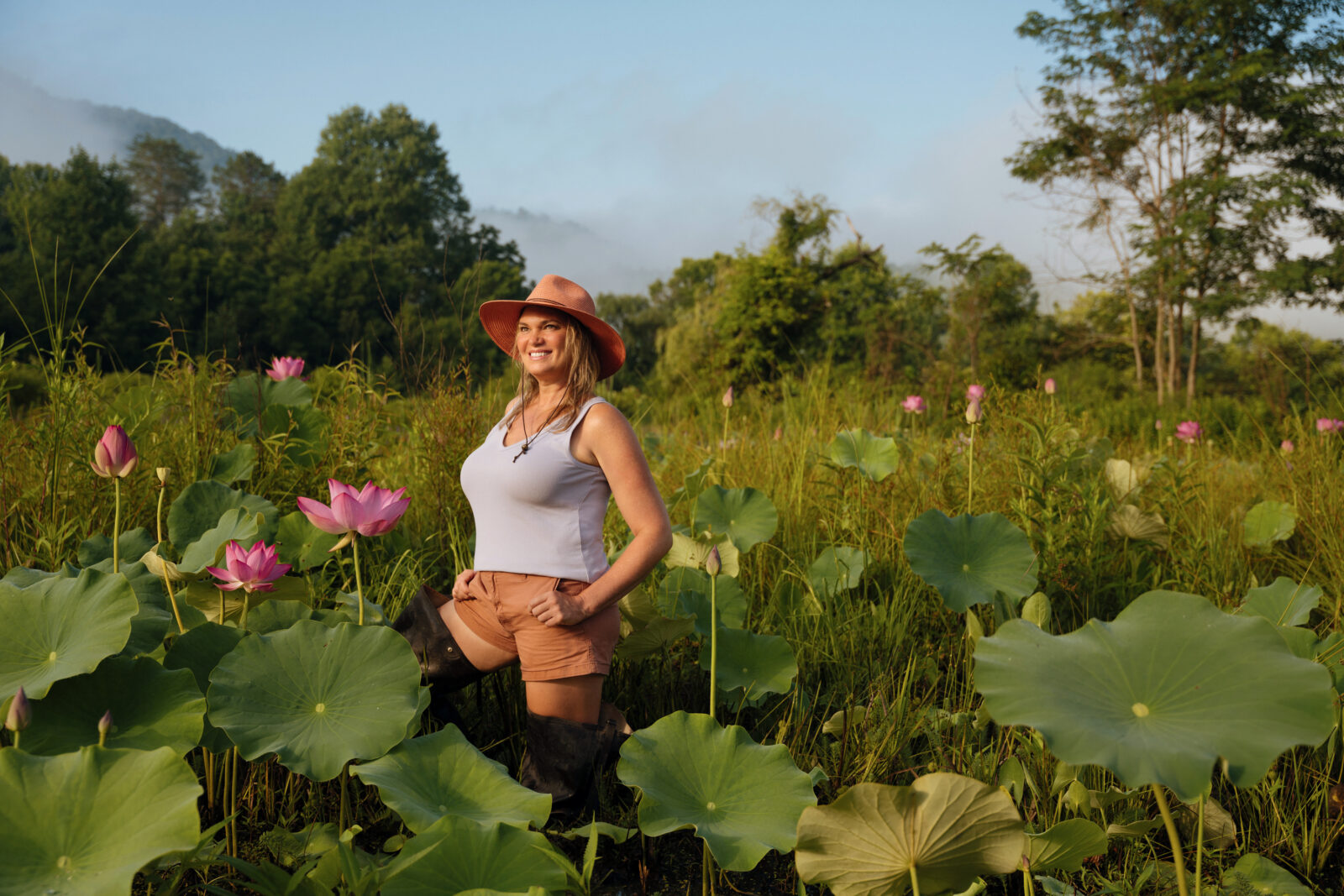 A woman stands in a water lily pond