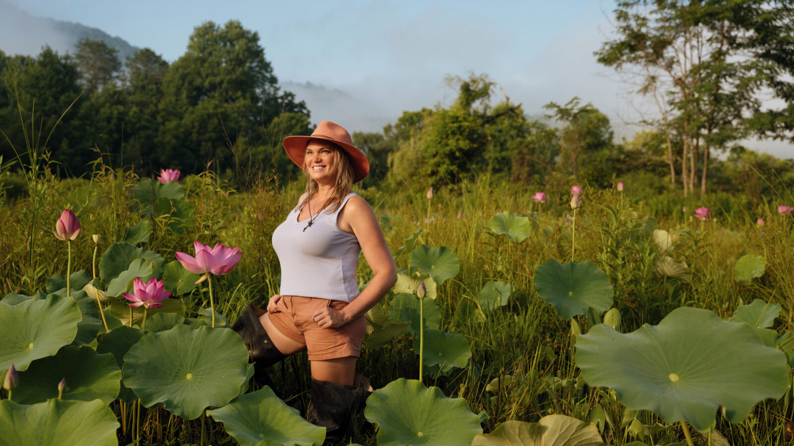A woman stands in a water lily pond