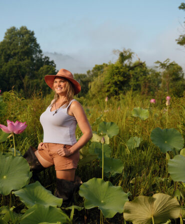 A woman stands in a water lily pond