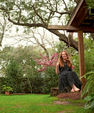 A woman swings on a swing in her garden