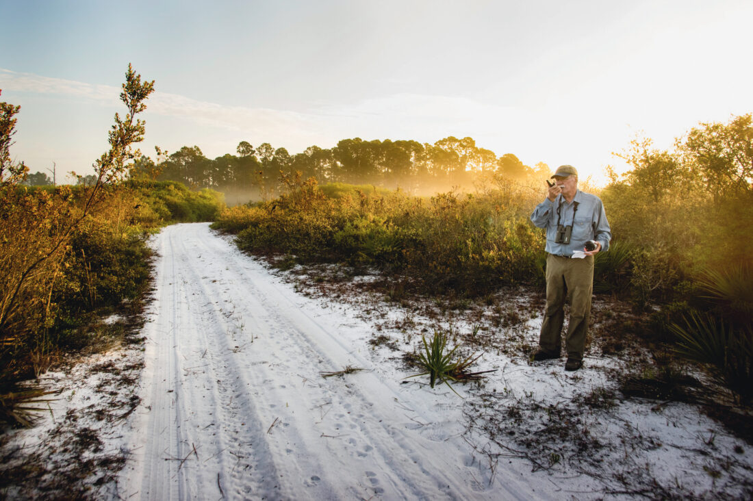A man stands in sandy dunes