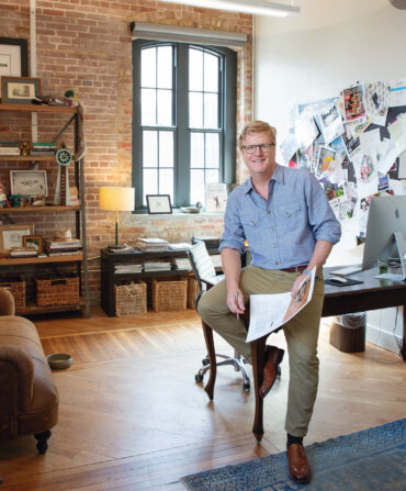 A man sits on a desk in an office