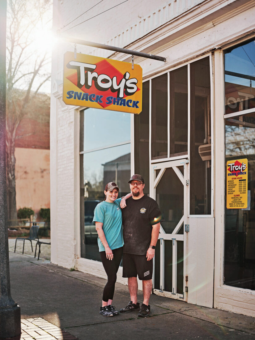 A couple stands outside a restaurant