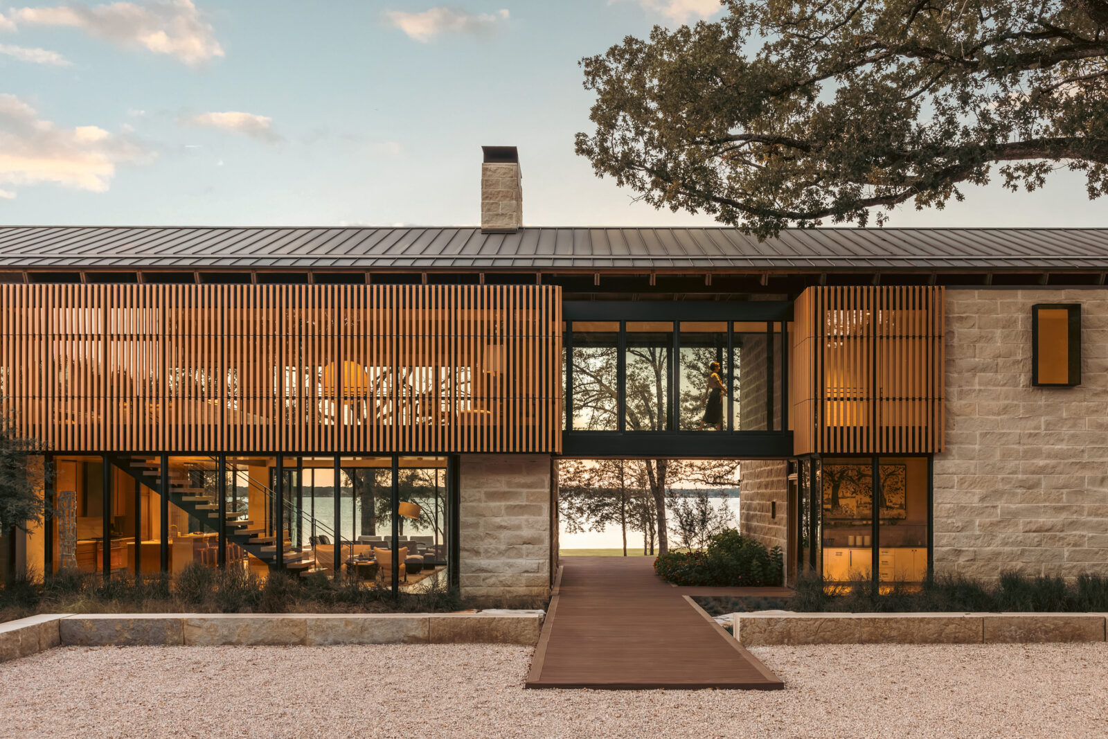 A lake house on the water with stone and wood textures