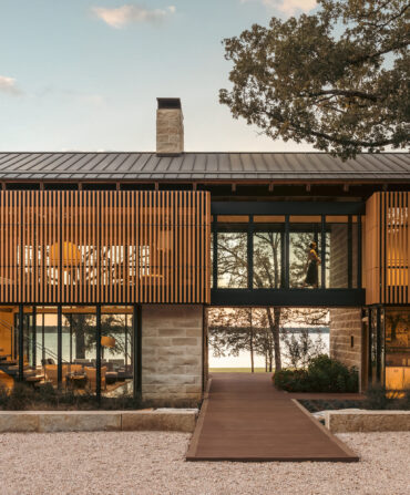 A lake house on the water with stone and wood textures