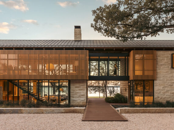 A lake house on the water with stone and wood textures