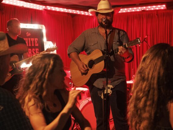People dance in front of a stage