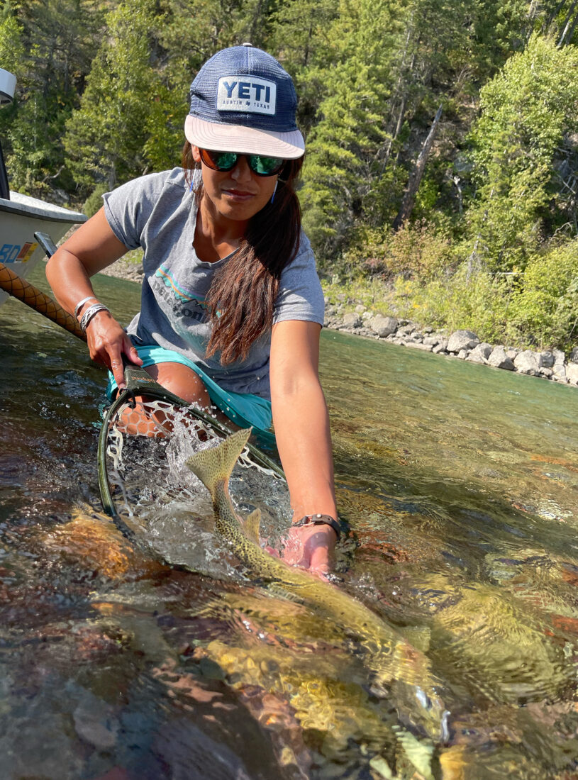 A woman with a fish in a river.