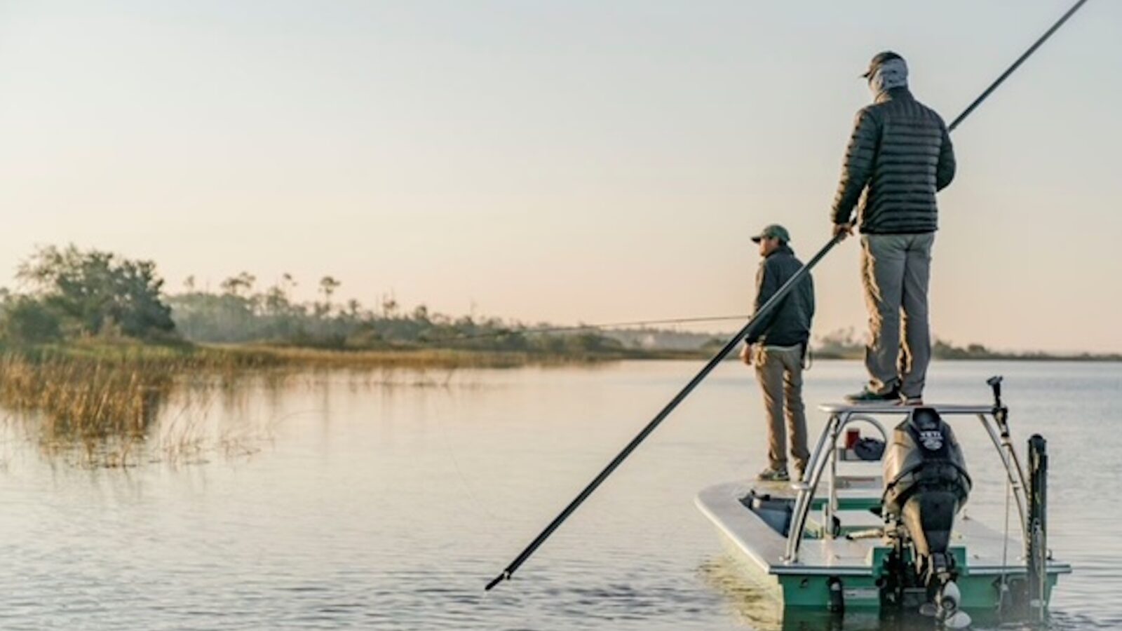 People fish while standing on a boat