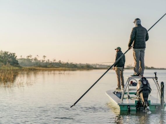 People fish while standing on a boat