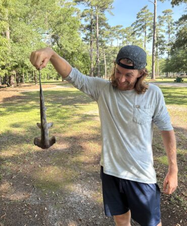 A man holds a hammerhead shark