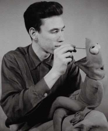 A man paints Mr. Kermit the Frog.