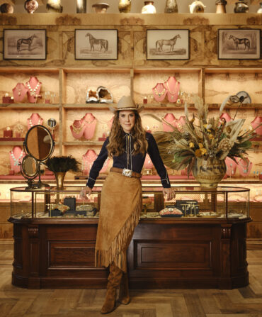 A woman in western clothes stands in a clothing store