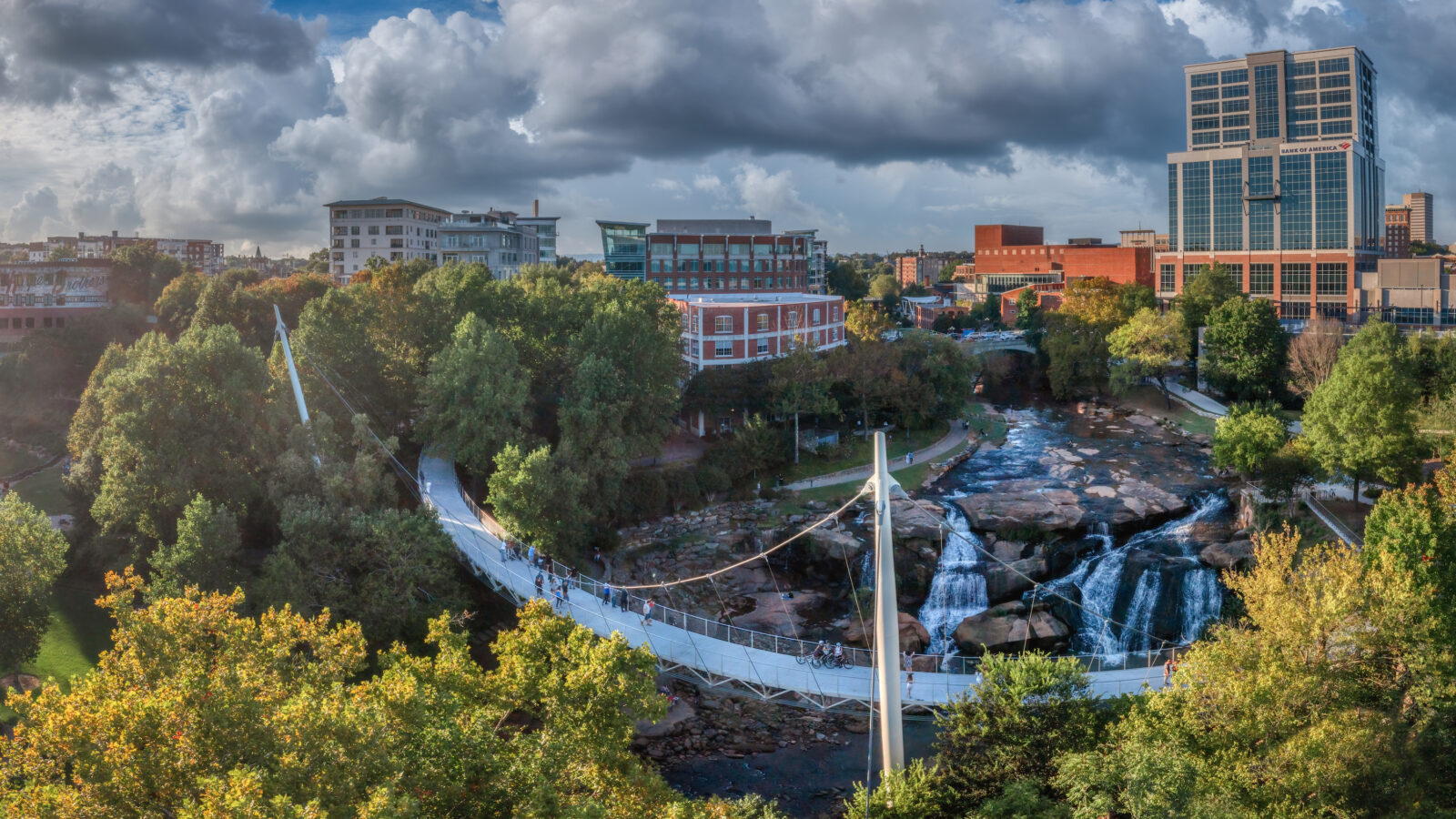 A bridge sweeps over a river before a cityscape