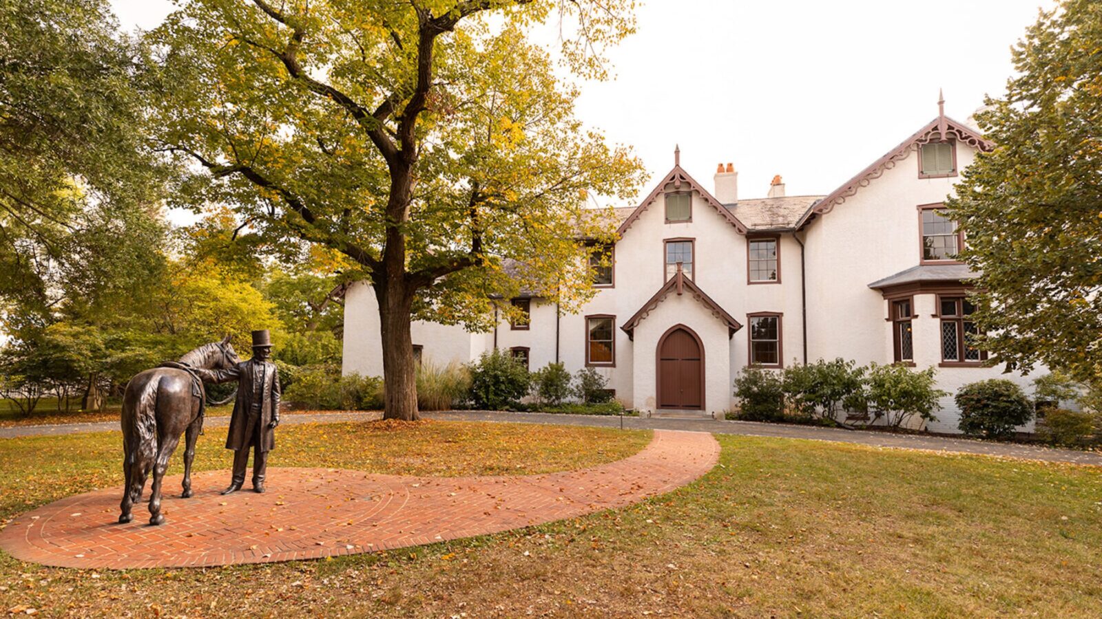 The front of a white house with brown trim and details