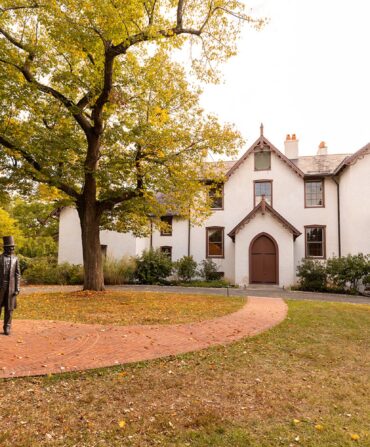 The front of a white house with brown trim and details