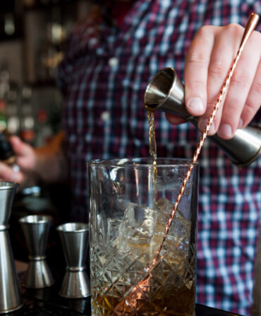 A bartender mixes bourbon