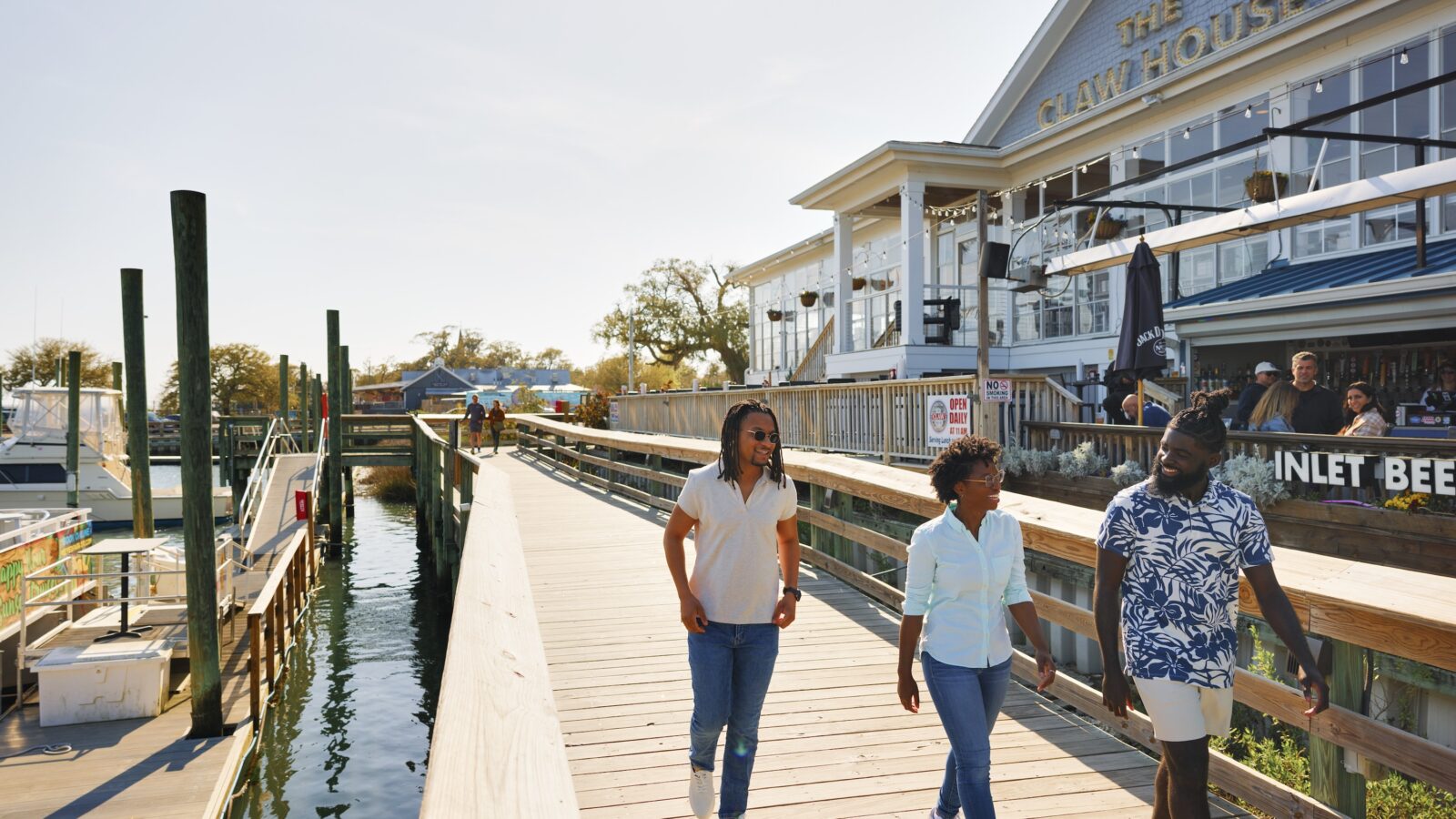 People stroll down a dock by the water