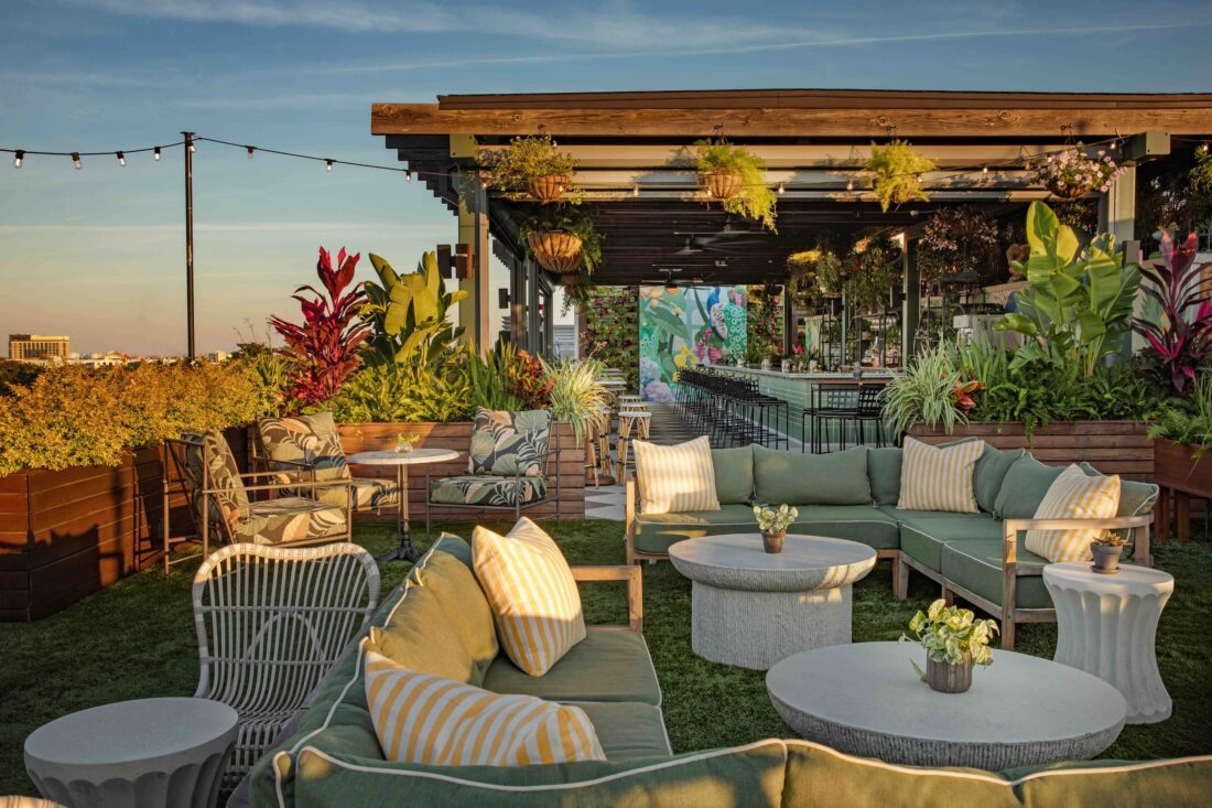 A rooftop bar filled with seating and plants
