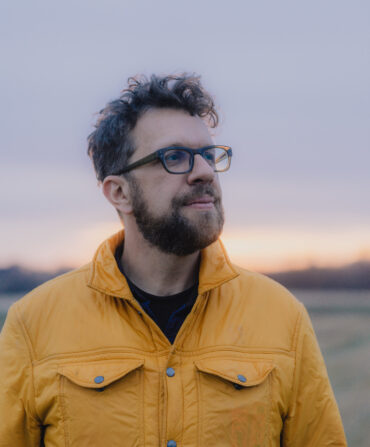 A portrait of a man in a yellow jacket
