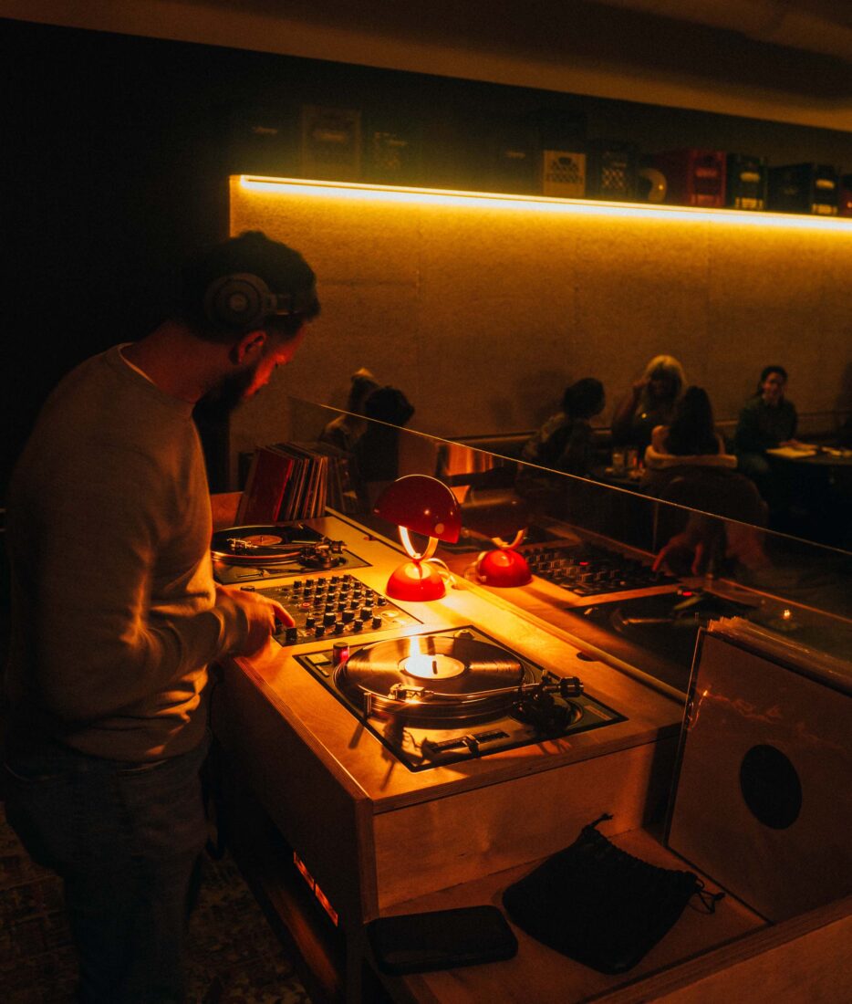 A dj booth at a bar with yellow lighting