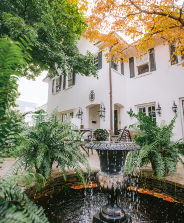 A fountain in a patio of a white house