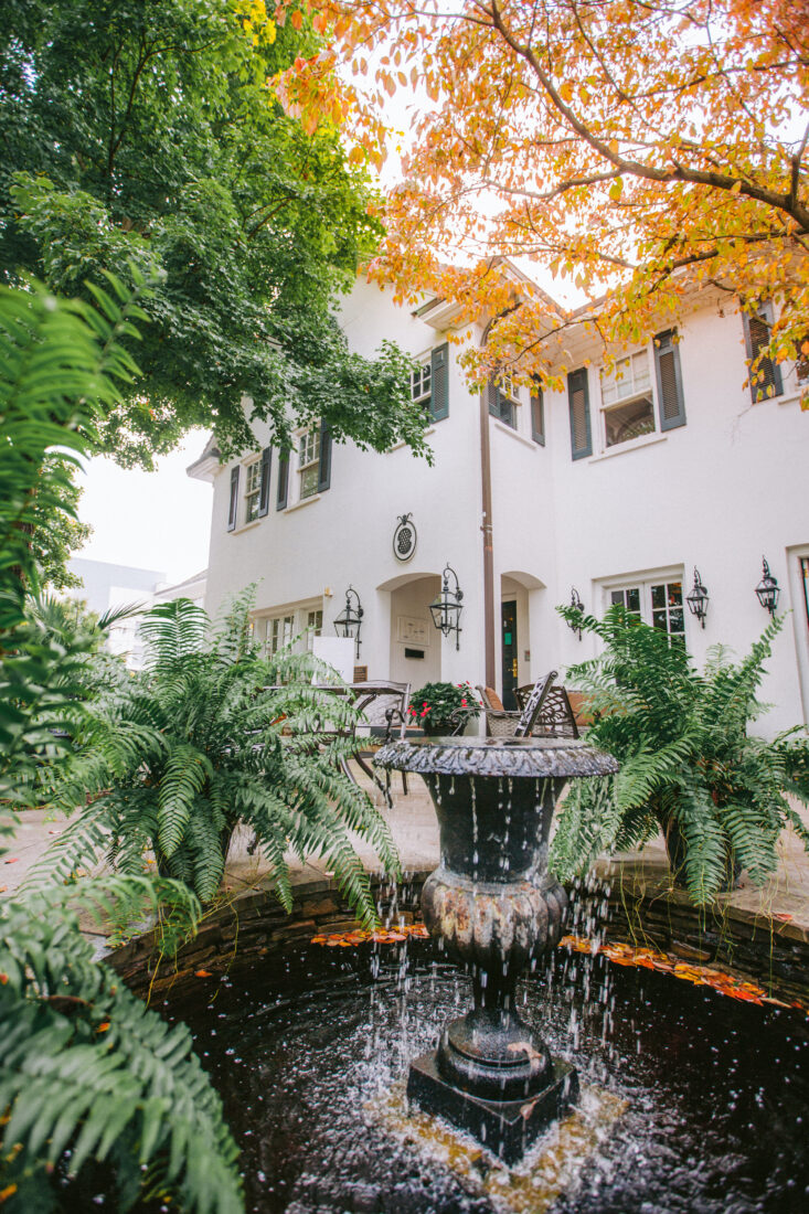 A fountain in a patio of a white house