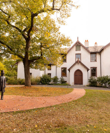 The front of a white house with brown trim and details