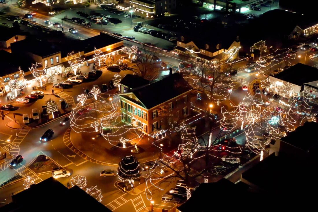 An aerial photo of a downtown area decorated with lights