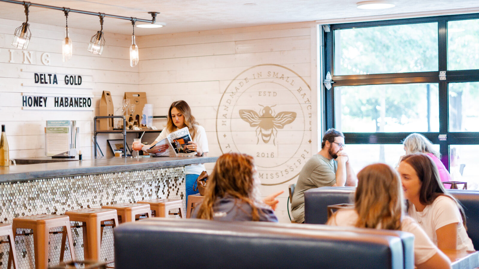 Inside a meadery shop with booths and people seated