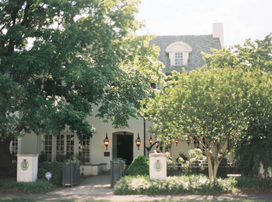 Outside a white house with greenery