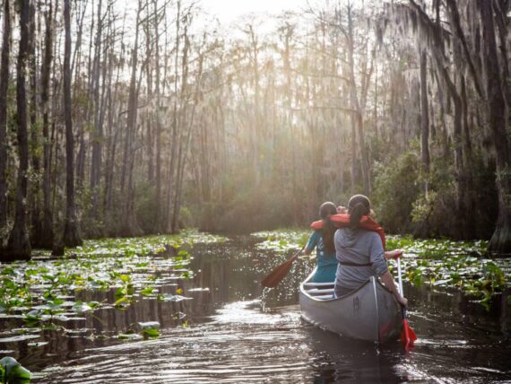 Two women canoeing through the Okefenokee Swamp