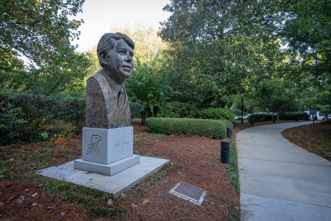 A statue of Jimmy Carter's head stands in a garden