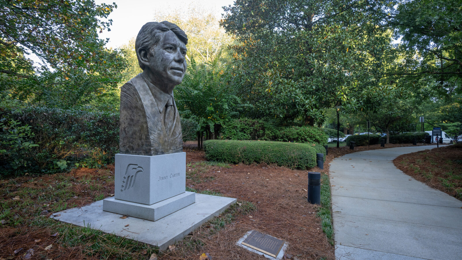 A statue of Jimmy Carter's head stands in a garden
