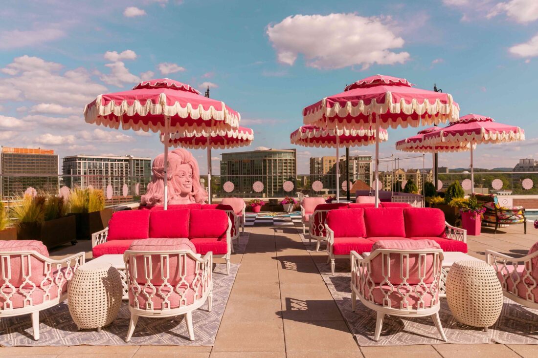 A rooftop bar with pink furniture